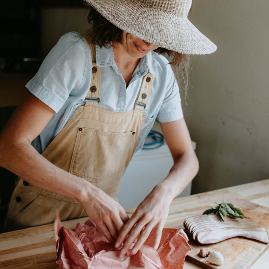Wrapping a cut of organic pork in butcher paper at Fresh Valley Farms